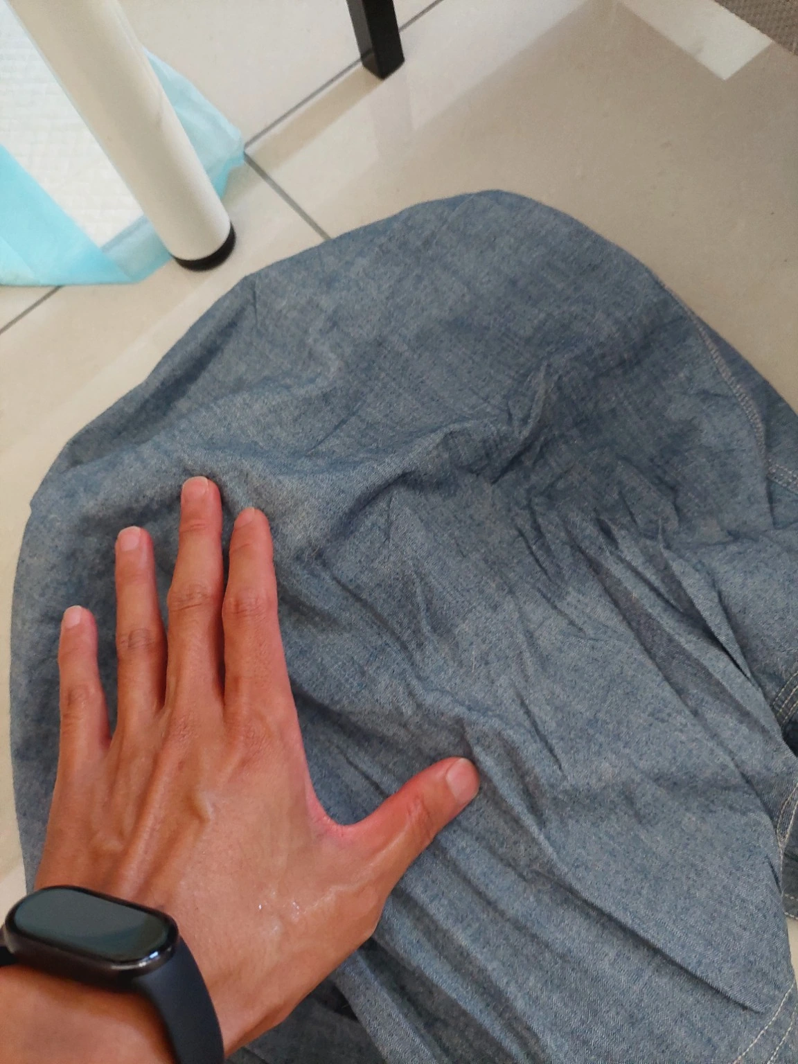 行軍床舊衣物上的濕痕近照;因未直接拍到排尿過程,仍只記為疑似尿液/疑似漏尿。